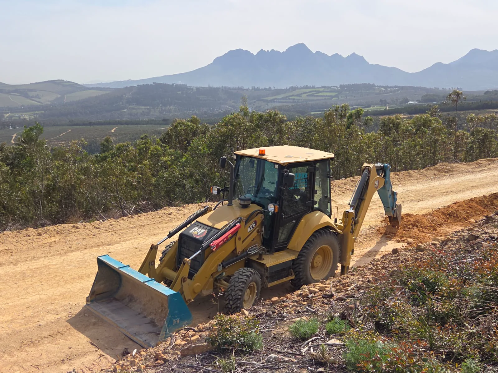 Mizpah Plant Hire TLB working on an access road near Stellenbosch