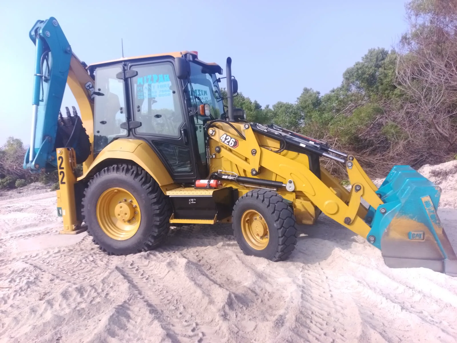 Mizpah Plant Hire TLB positioned on a sandy worksite
